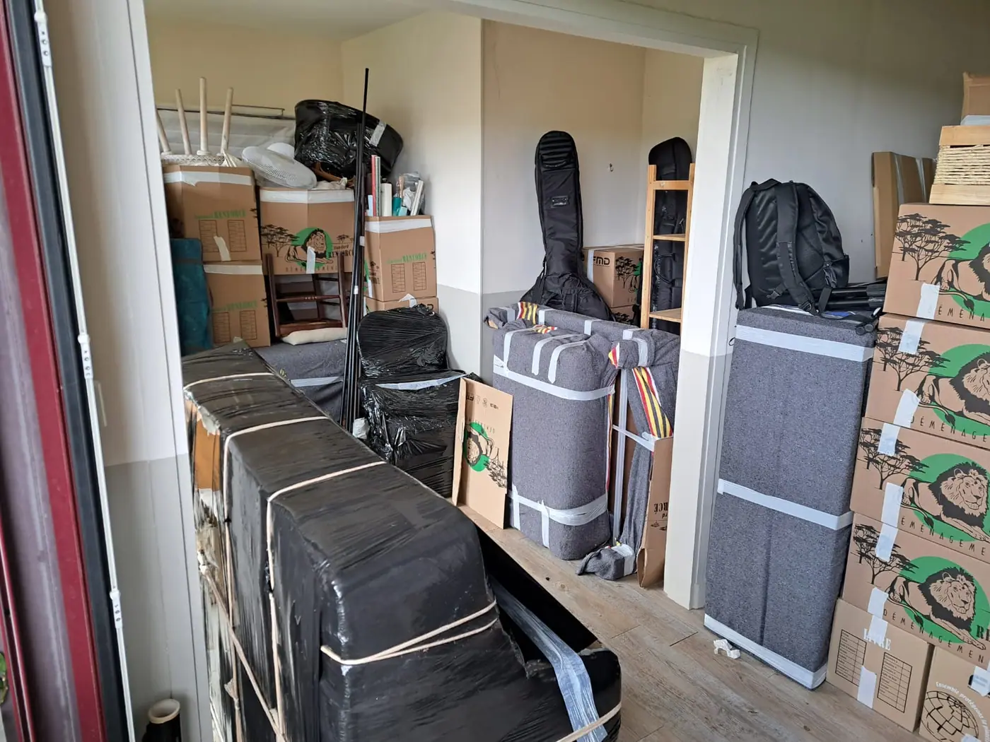 Emballage professionnel par les déménageurs Luxy Move : meubles protégés sous couvertures, cartons étiquetés salon prêts pour le déménagement