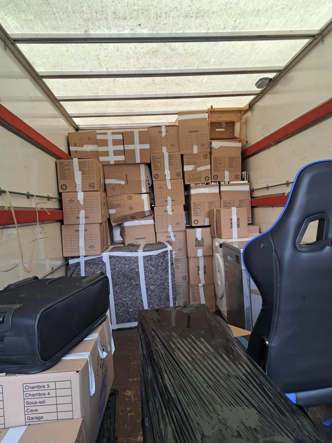 Fauteuils emballés et sanglés par les déménageurs Luxy Move avant chargement dans le camion de déménagement