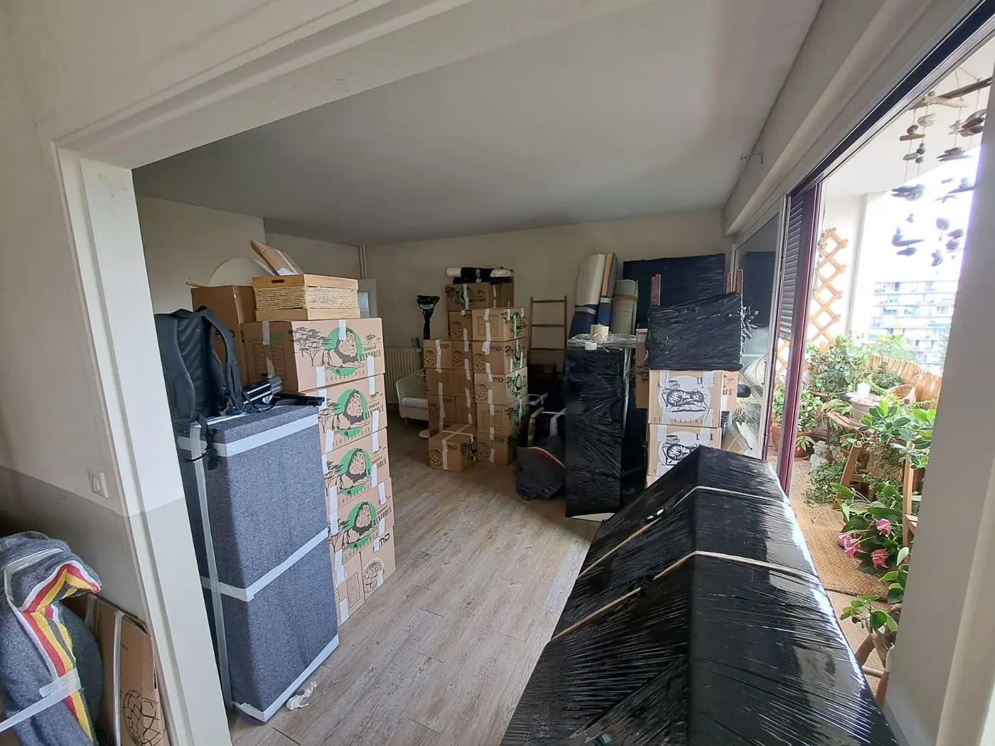 Appartement parisien préparé pour le déménagement : cartons, meubles emballés et housses de protection installés par nos déménageurs