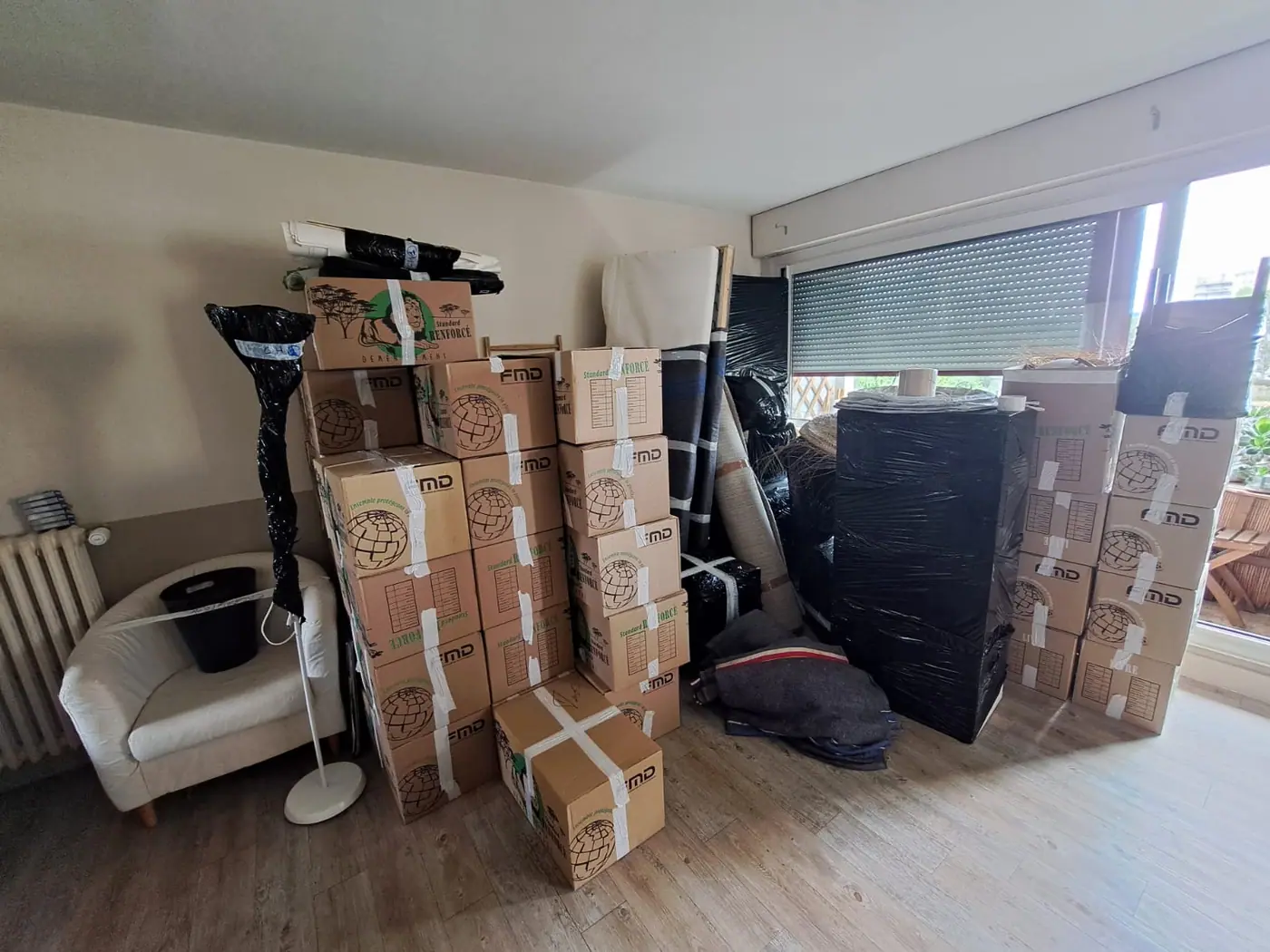 Chargement organisé d’un déménagement : cartons étiquetés par pièce, meubles emballés et fauteuils transportés par les déménageurs Luxy Move