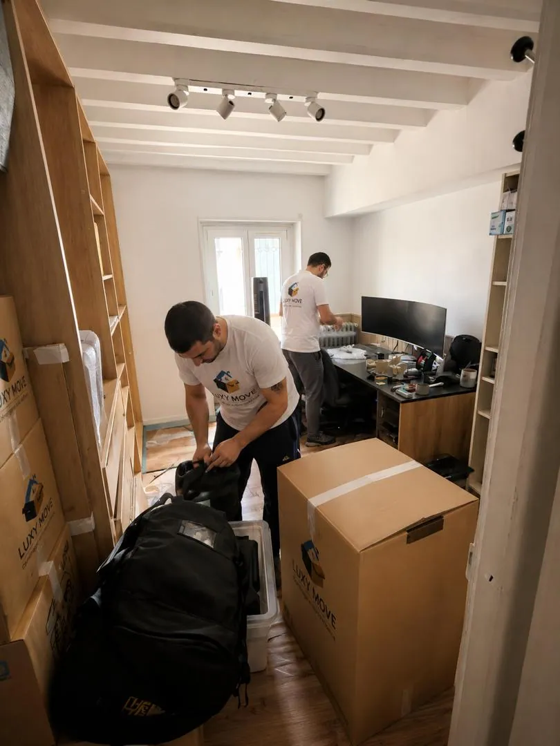 Équipe Luxy Move en intervention : déménageurs en uniforme transportant des meubles emballés en couvertures de protection